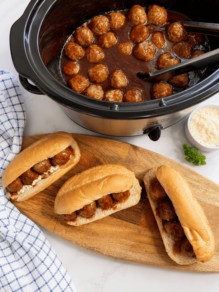 Grape jelly meatballs cooking in a slow cooker with a sweet and tangy BBQ sauce. This easy crockpot grape jelly meatballs recipe is made with frozen meatballs and simple ingredients for the perfect party appetizer.