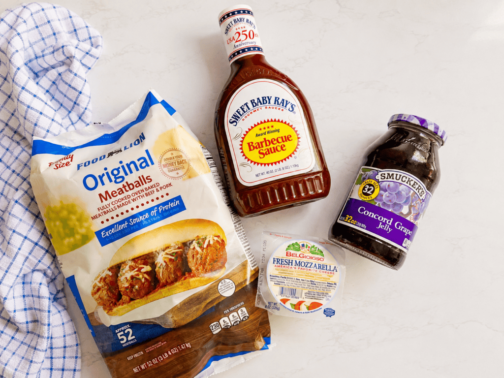 Ingredients for grape jelly meatballs including frozen meatballs, barbecue sauce, concord grape jelly, and fresh mozzarella cheese for easy slow cooker meatballs and delicious meatball subs.