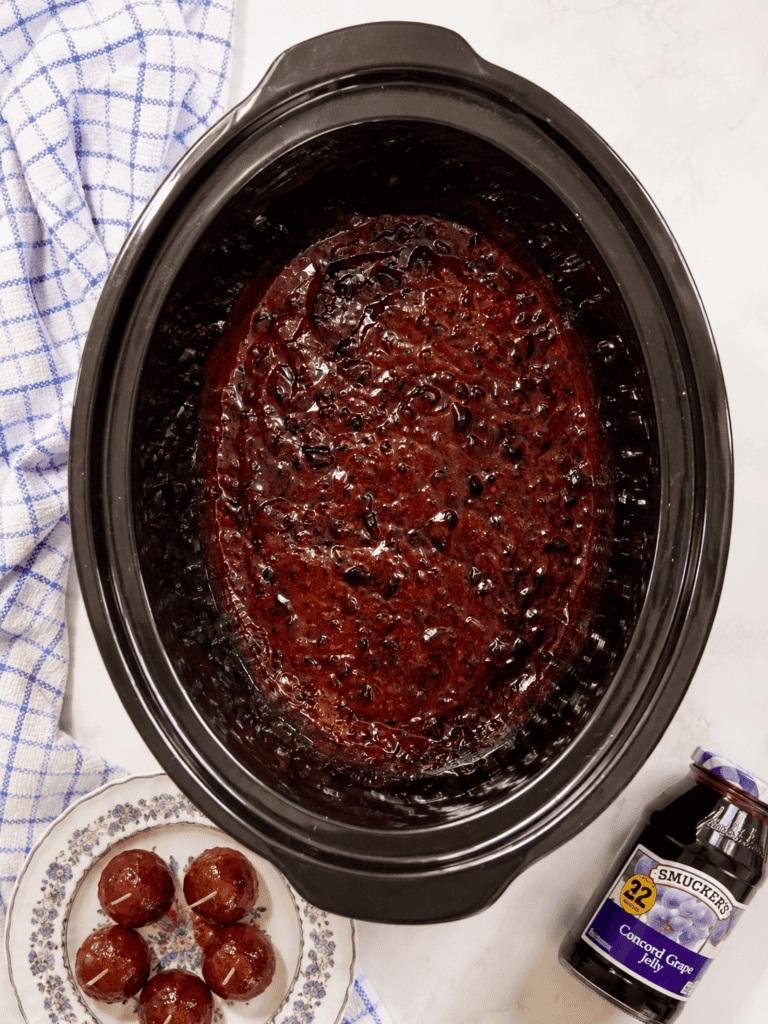 Sweet and tangy grape jelly BBQ sauce melting together in a crockpot before adding frozen meatballs. This easy grape jelly meatballs recipe starts with just a few simple ingredients.