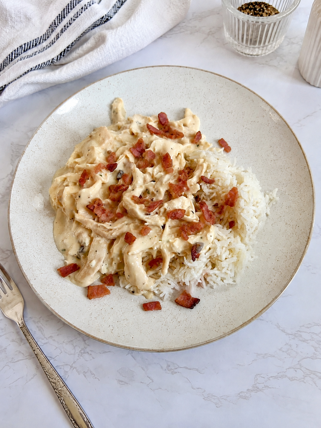 Creamy bacon ranch chicken served over fluffy white rice with crispy bacon garnish for an easy weeknight dinner recipe.
