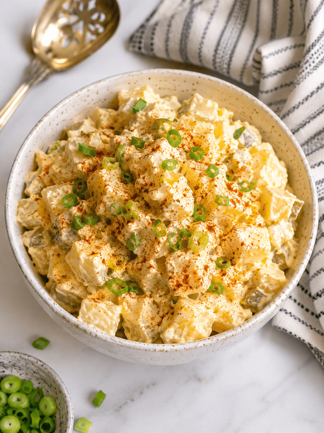 Creamy classic white potato salad made with Yukon Gold potatoes, hard-boiled eggs, mayonnaise, yellow mustard, dill pickles, and green onions, garnished with paprika. This easy homemade potato salad recipe is the perfect side dish for summer picnics, backyard barbecues, cookouts, potlucks, and family gatherings.