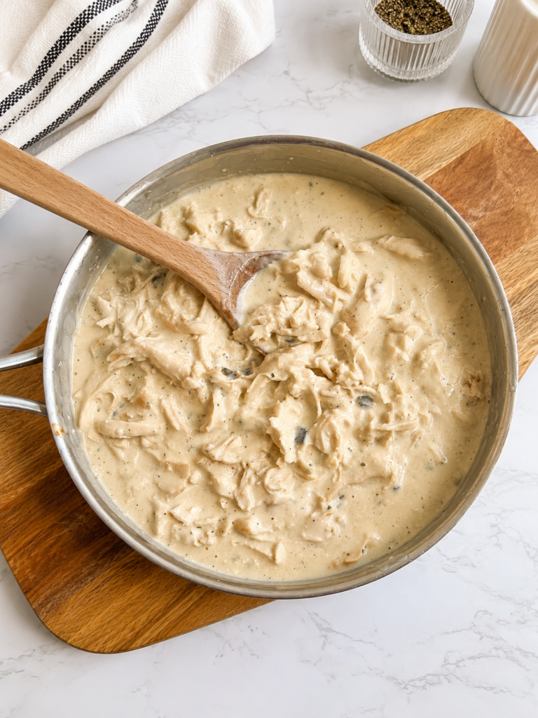 Shredded chicken folded into rich ranch cream sauce for homemade bacon ranch chicken served over rice or mashed potatoes.
