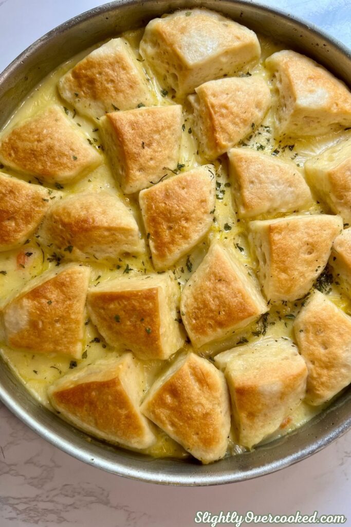 Golden brown biscuit dumplings over creamy chicken and vegetables