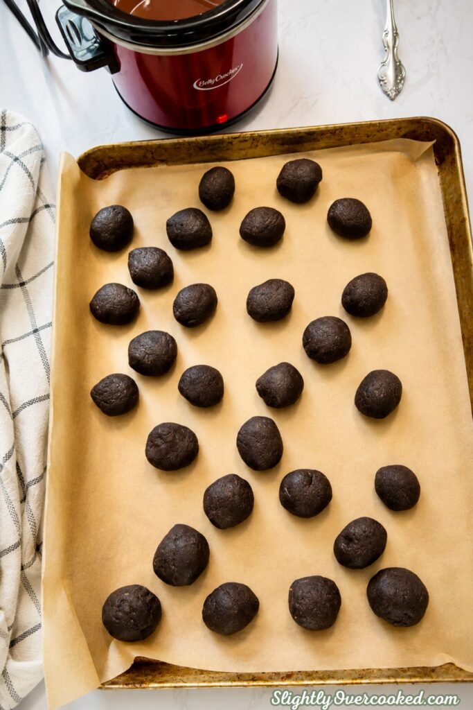 Uncoated Oreo truffle balls arranged on parchment paper before dipping in melted chocolate