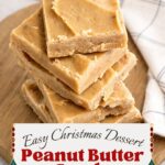 Homemade peanut butter candy squares stacked on a wooden board with a farmhouse kitchen towel