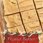 Stack of homemade peanut butter candy squares arranged on a wooden board with a farmhouse towel in the background