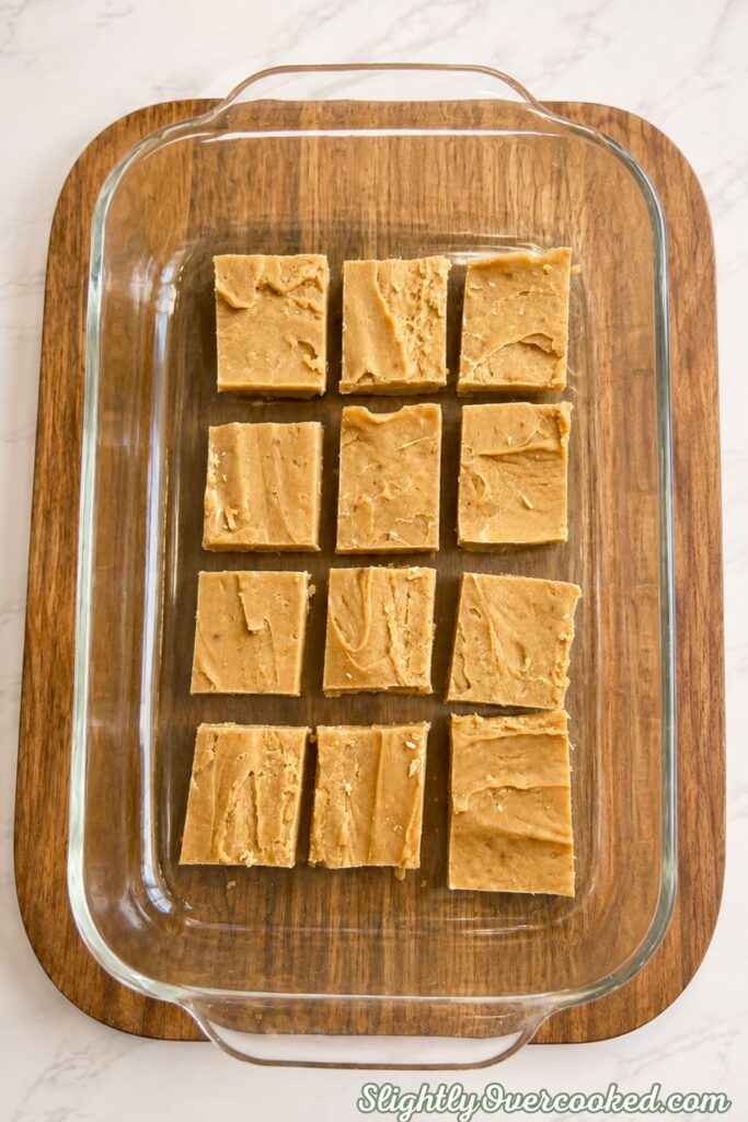 Squares of creamy peanut butter candy arranged in a glass baking dish